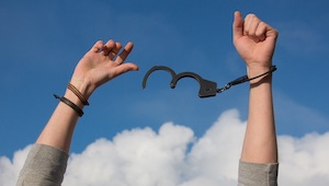 Drug Crime Defense Attorney in Los Angeles County Person’s Hands Raised in the Air with Opened Handcuffs on Their Wrists