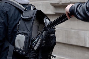 Person Grabbing a Camera Out of Another Person’s Backpack