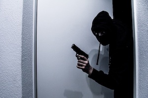 Orange County Theft Defense Attorney Robber Sneaking into a Home with a Gun in his Hand and a Ski Mask on His Face